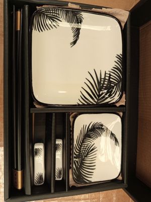 un plateau noir et blanc orné d'un miroir et un plateau décoré d'un motif de feuille de palmier