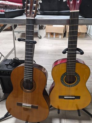 two guitars that are sitting on a stand in the room