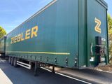 un semi-remorque vert garé sur le bord de la route
