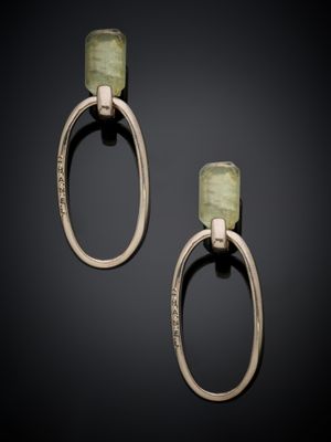 a pair of gold and green stone earrings on a black background