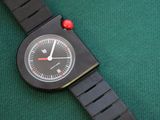 a black watch with a red dot on the face