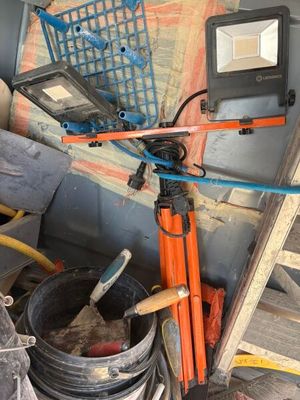 un ordinateur portable posé sur un trépied à côté d'une pile d'outils