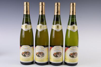 four bottles of wine are lined up on a white surface