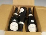 trois bouteilles de vin dans un carton sur une table