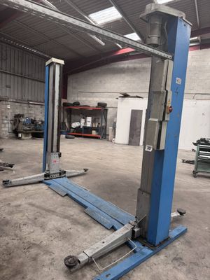 deux ascenseurs bleus rangés l'un à côté de l'autre dans un garage