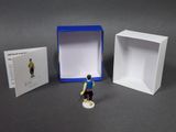 a small figurine of a man standing in front of a box