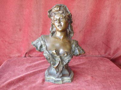 bronze bust of a woman on a red velvet background