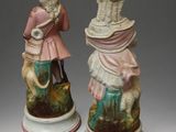 pair of figurines of a man and a woman with a dog