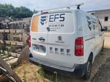 a van that is parked next to a pile of wood