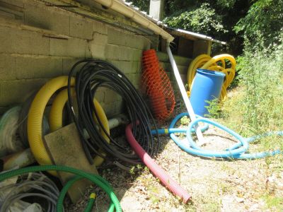 un tas de tuyaux à côté d'un bâtiment, au bord de la route