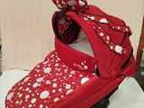 red and white polka dot baby stroller with a bow on top