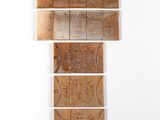 trois morceaux de bois sont empilés les uns sur les autres contre un mur blanc