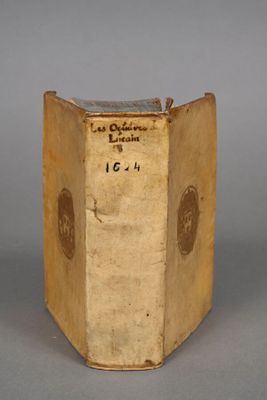 an old book sitting on top of a table on a gray surface