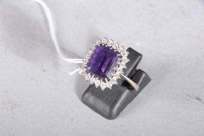 an image of a ring with a purple stone surrounded by diamonds