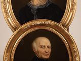 two framed portraits of a man and a woman in formal clothing
