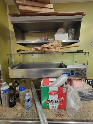 une cuisine avec un évier et un plan de travail sur lequel se trouvent de nombreux aliments