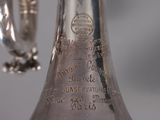 a silver vase that has a handle on it