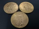 three gold coins sitting on top of each other on a black surface