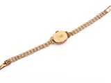 a close up of a gold wrist watch on a white surface