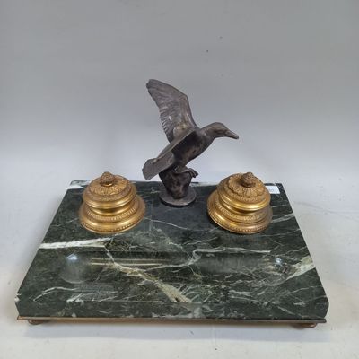 Une GARNITURE de bureau en bronze à décor d'oiseau sur un ro…