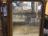 un grand miroir posé sur une chaise dans une pièce