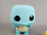 a blue and yellow pokemon figure next to a blue and yellow ball