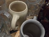 many cups and mugs sitting on a tray on a table