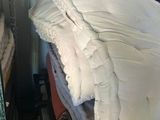 a stack of pillows and blankets on a shelf in a room