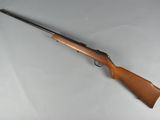a rifle that is laying on a white surface