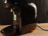 a black coffee maker sitting on a wooden table