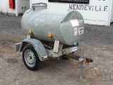 a trailer with a tank attached to it in front of a building