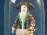 a figurine of a man in a hat and coat under a glass dome