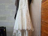 a wedding dress hanging on a clothes rack in a room