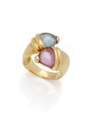 un gros plan d'une bague en or sertie de deux pierres