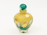 une bouteille en verre jaune avec un bouchon vert
