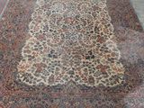 Un tapis persan ancien est posé sur le sol d'une pièce.