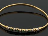 un bracelet en or serti d'émeraudes et de diamants