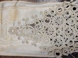 une robe blanche ornée d'un nœud, posée sur un parquet