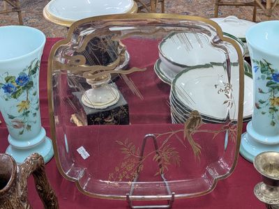 Plusieurs vases et assiettes sont posés sur une table recouverte d'une nappe rouge.