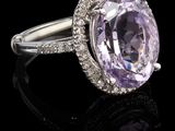 gros plan d'une bague avec une pierre violette entourée de diamants