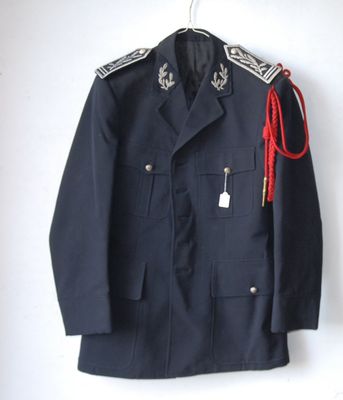 navy blue military jacket with a red cord on a hanger