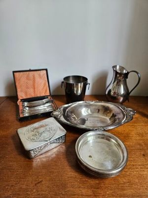 une table en bois sur laquelle sont disposés des plats et des couverts en argent