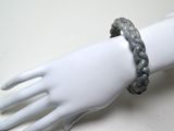 une main de mannequin blanche portant un bracelet