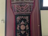 an old picture of a carpet hanging on a wall next to a window