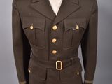 un uniforme militaire sur un mannequin, devant un fond gris