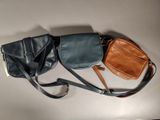 trois sacs à main en cuir sont alignés sur une surface blanche
