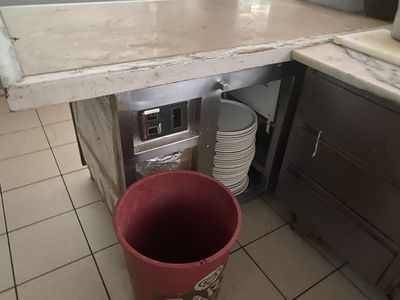 a red bucket sitting in the middle of a kitchen