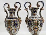 two vases sitting on top of a white surface next to each other