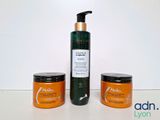 un flacon de lotion et deux pots de lotion posés sur une table