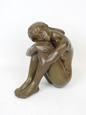 statue of a woman sitting on her knees with her hands on her knees